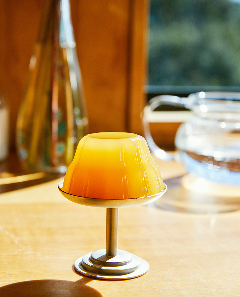 Passion Gelée on a pedestal serving dish on a sunny wood table