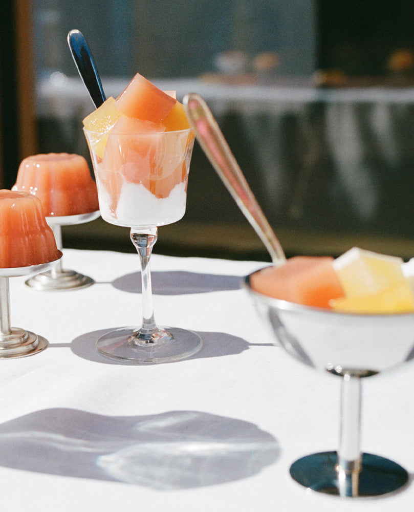 Tablescape of Gelée dessert cups of varying heights and styles on a sunny table